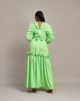 A lady wearing the Ine maxi dress featuring a draped V neckline, gathered waist detailing, and ruched hem accents.