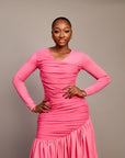 A lady wearing the Ine maxi dress featuring a draped V neckline, gathered waist detailing, and ruched hem accents.