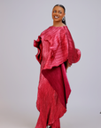 Woman wearing an elegant fuchsia pleated gown with ruffle detailing and asymmetrical layers.
