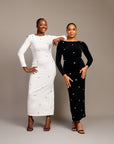 Women wearing the Zola maxi dress with bateau neckline, rhinestone embellishments, long sleeves, deep V-back plunge, and hemline slit.
