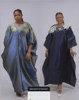 Woman wearing a shiny metallic blue-green cupped chain dress with loose sleeves and embellished neckline.
